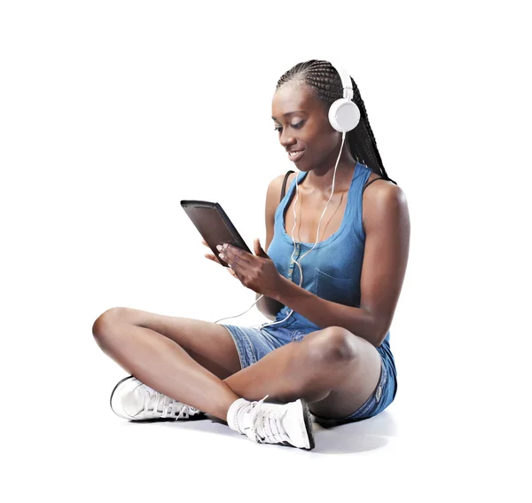 Улыбающаяся молодая африканская женщина с помощью планшета — стоковое фото