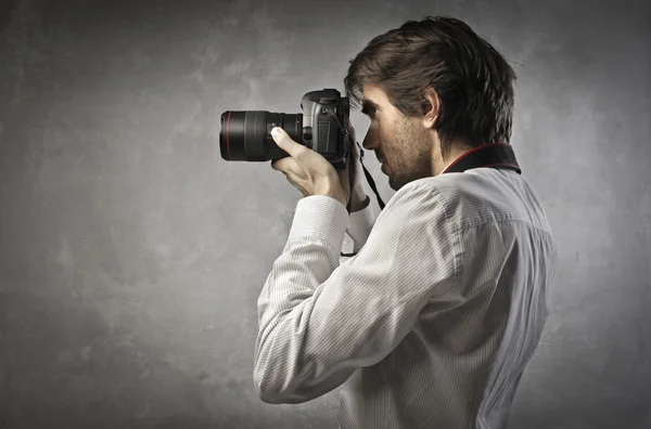 Homem tirando fotos com uma câmera — Fotografia de Stock