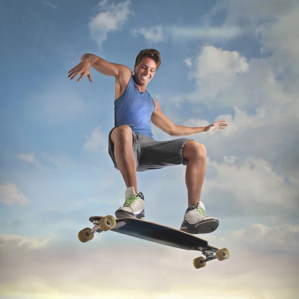 Lachende jongeman skateboarden — Stockfoto