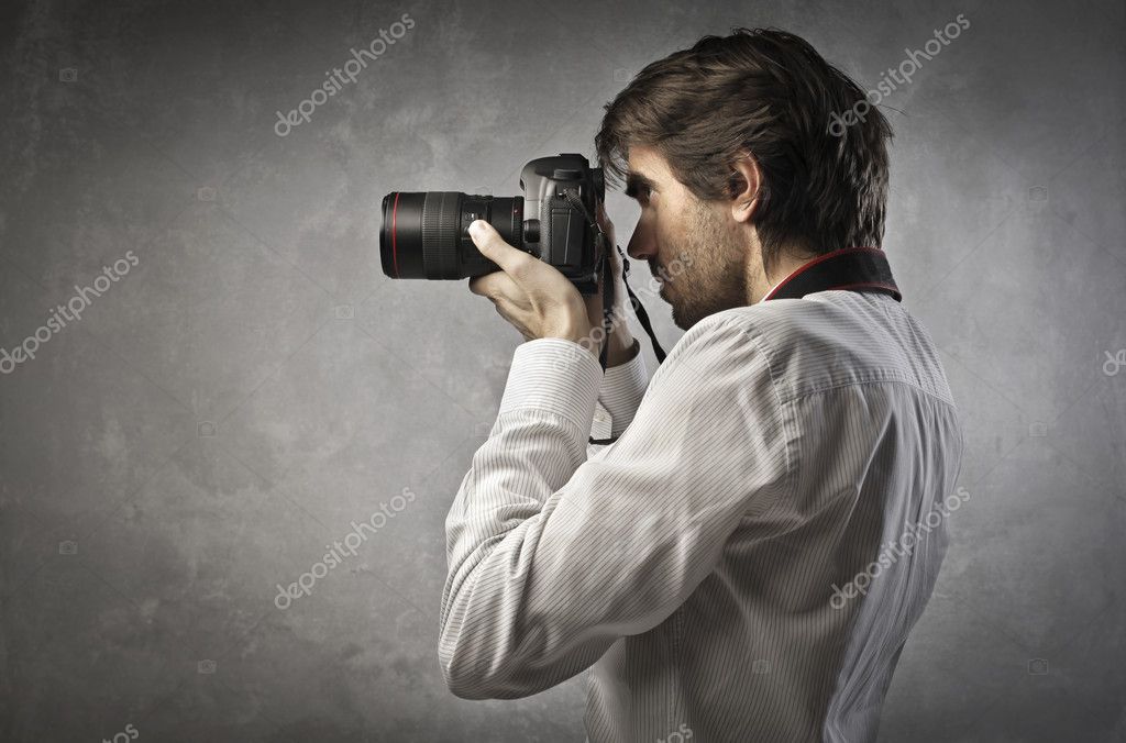 Фотограф. Мужчина с фотоаппаратом. Человек фотографирует. Профессия фотограф. Человек фотографирует на фотоаппарат.
