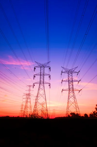 Pilões de electricidade ao pôr-do-sol — Fotografia de Stock