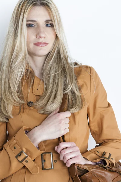 Portrét ženy nosí hnědý kabát s kabelka — Stock fotografie