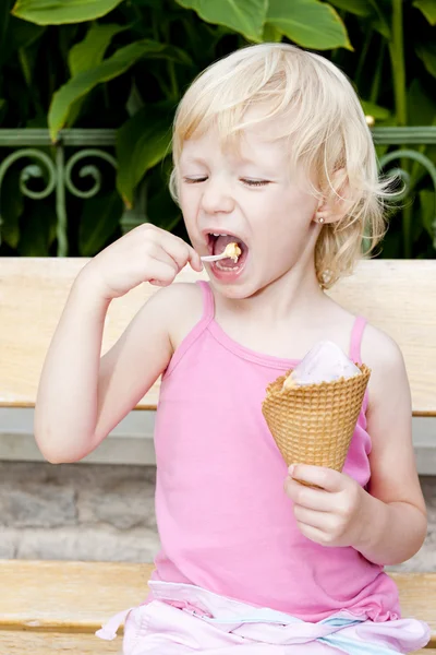Petite fille avec de la crème glacée assis sur le banc — Photo