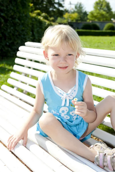 Маленькая девочка на скамейке — стоковое фото