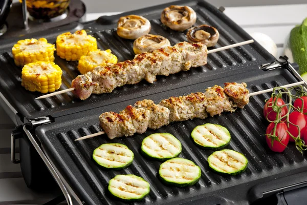 Meat skewers and vegetables on electric grill — Stock Photo, Image