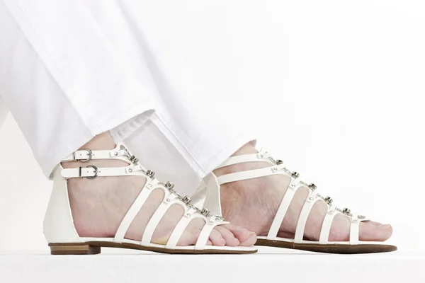 Detail van zittende vrouw dragen witte sandalen — Stockfoto
