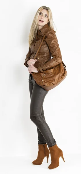 Seisova nainen yllään ruskeat vaatteet ja muodikas ruskea kengät — kuvapankkivalokuva
