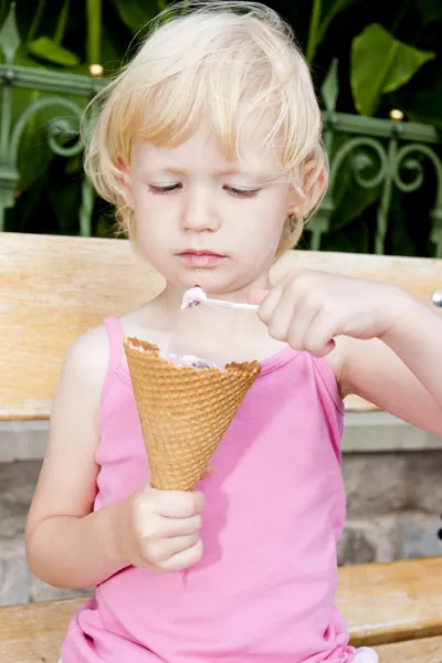 Little girl with ice cream sitting on bench — Stock Photo, Image