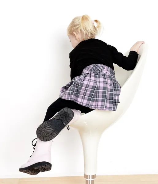 Liten flicka sitter på stol — Stockfoto