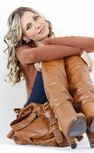 Donna che indossa stivali marroni alla moda con una borsa — Foto Stock
