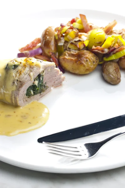 Baked pork tenderloin filled with spinach and goat cheese on cre — Stock Photo, Image