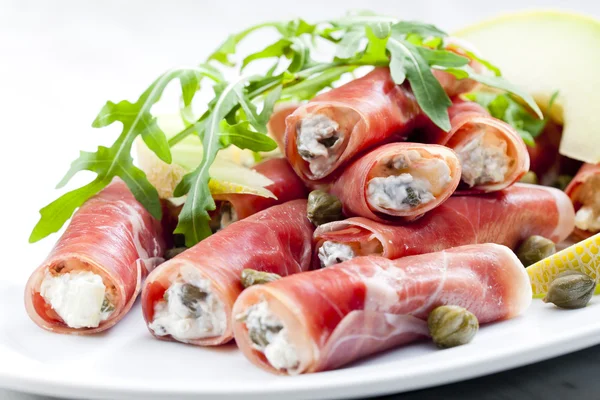 Parma ham rolls filled with cream cheese, Galia melon and capers — Stock Photo, Image