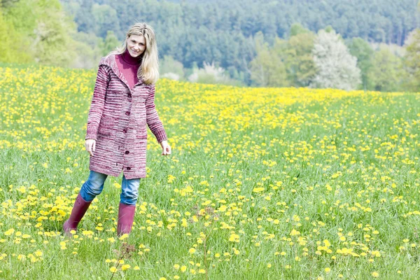 Mujer con botas de goma de pie en la pradera de primavera — Foto de Stock