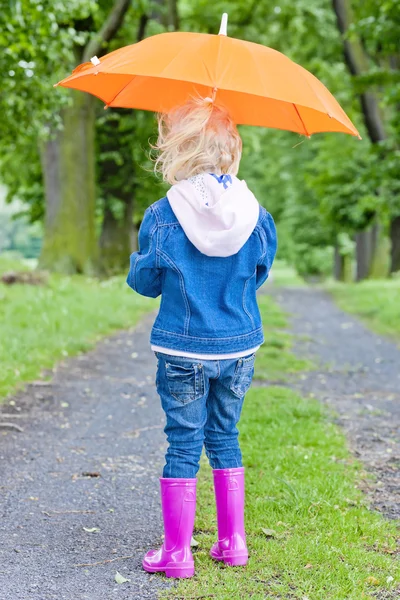 Kislány tavaszi sikátorban esernyő — Stock Fotó
