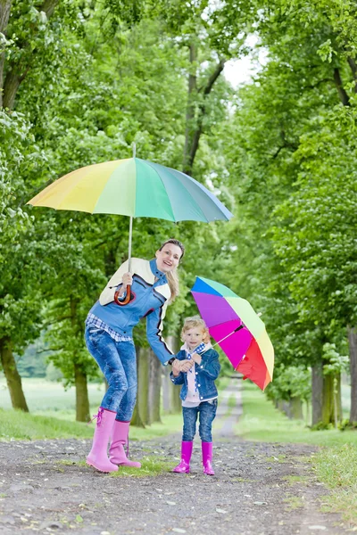 妈妈和女儿带着雨伞在春巷里 — 图库照片