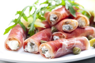 Parma ham rolls filled with cream cheese, Galia melon and capers clipart