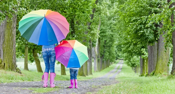 Mère et sa fille avec des parasols dans l'allée du printemps — Photo