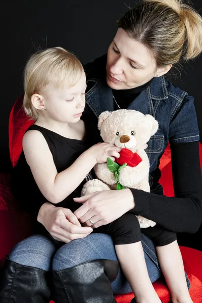 Madre con su pequeña hija sosteniendo osito de peluche — Foto de Stock