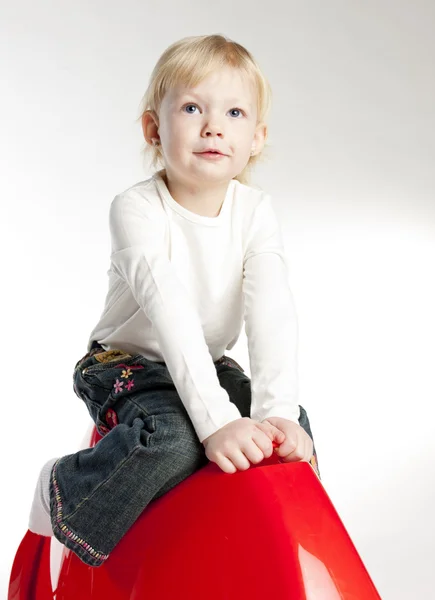 Маленькая девочка сидит на качелях — стоковое фото