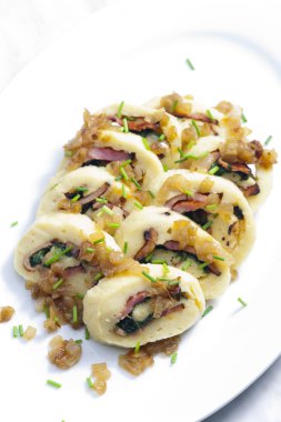 Roll from potato dough filled with spinach and bacon clipart