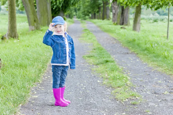 Klein meisje dragen van rubber laarzen in voorjaar steegje — Stockfoto