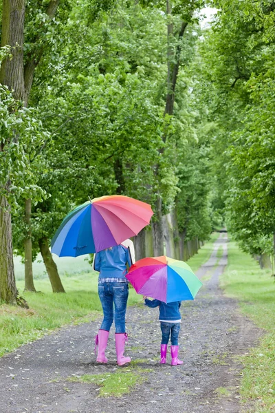 봄 골목에서 우산을 들고 있는 어머니와 딸 — 스톡 사진