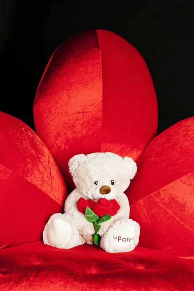 Teddy bear on red armchair — Stock Photo, Image