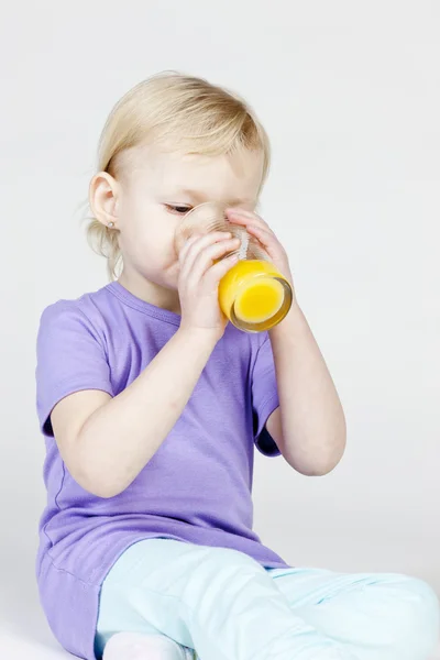 Retrato de menina bebendo suco de laranja — Fotografia de Stock