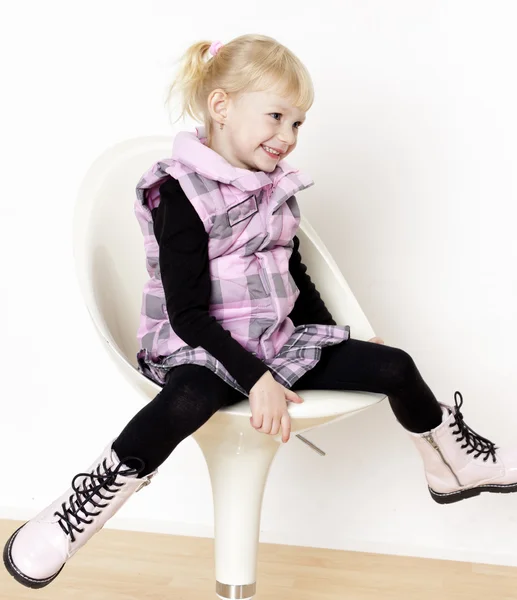 Liten flicka sitter på stol — Stockfoto