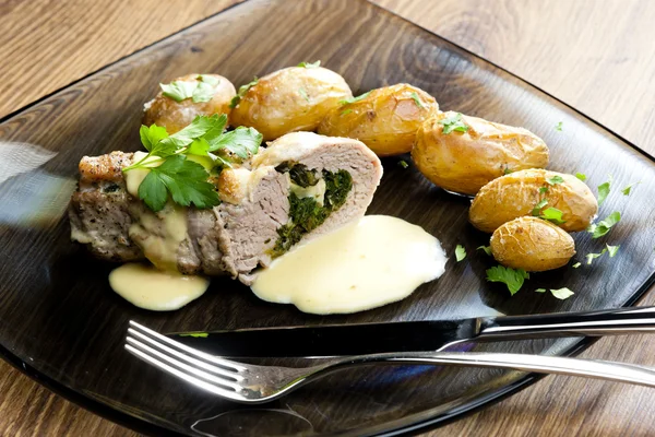 stock image Baked pork tenderloin filled with spinach and goat cheese on cre