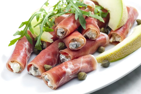 stock image Parma ham rolls filled with cream cheese, Galia melon and capers