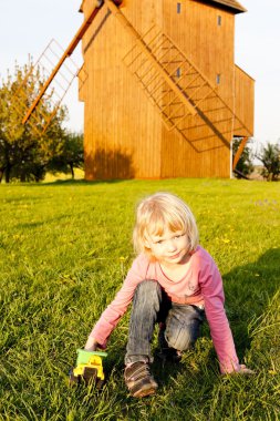 Playing little girl at wooden windmill, Stary Poddvorov, Czech R clipart