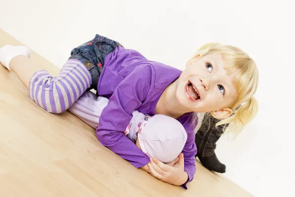 Klein meisje spelen met een pop — Stockfoto