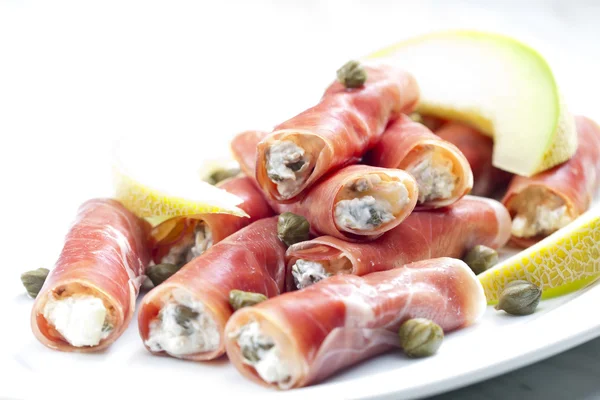 stock image Parma ham rolls filled with cream cheese, Galia melon and capers