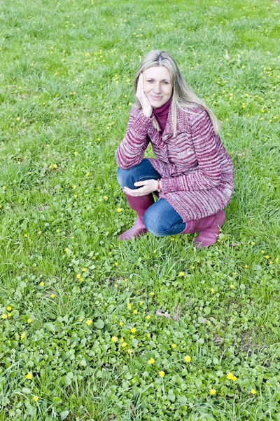 Woman wearing rubber boots on spring meadow — Stockfoto