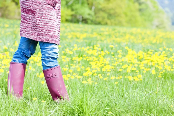 Detalhe da mulher usando botas de borracha no prado da primavera — Fotografia de Stock