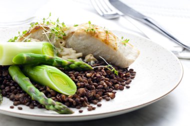 Butterfish with green lentils, leek and green asparagus clipart