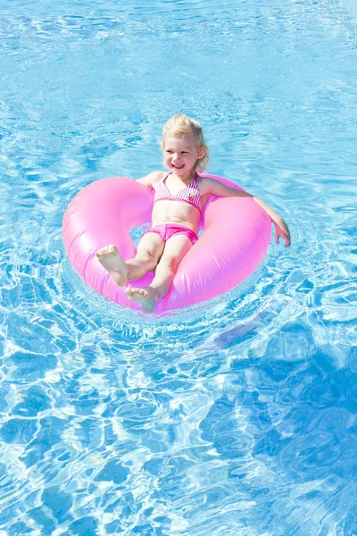 stock image Little girl with rubber ring in swimming pool