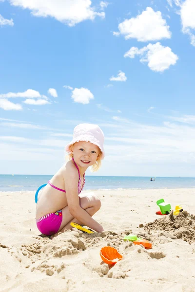 Little girl playing on the beach at sea — Stock Photo, Image