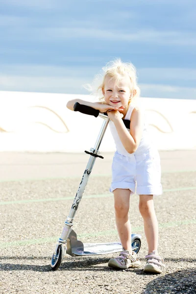 Маленькая девочка на скутере — стоковое фото