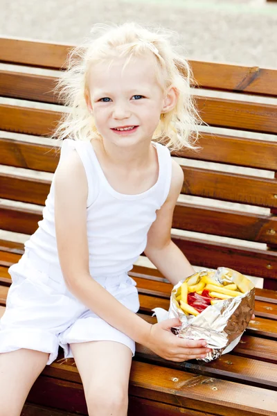 Маленька дівчинка їсть фішки — стокове фото