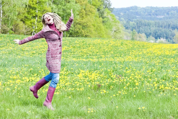 Mujer con botas de goma en el prado de primavera — Foto de Stock