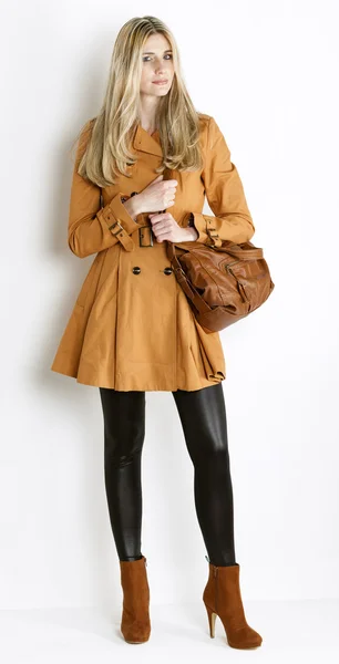 常设女人穿外套及时尚棕色的鞋与 h — 图库照片