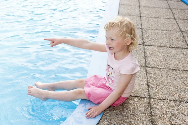 スイミング プールのそばで座っている小さな女の子 — ストック写真