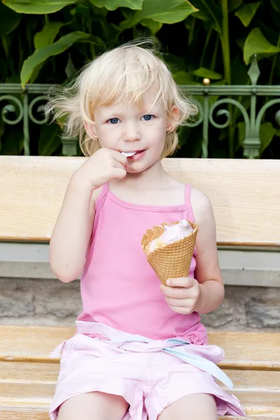 Little girl with ice cream sitting on bench — Stock Photo, Image