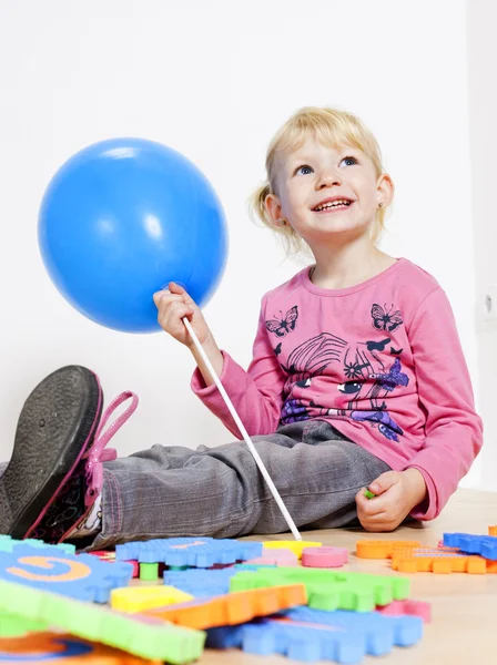 Играя маленькая девочка держит воздушный шар — стоковое фото
