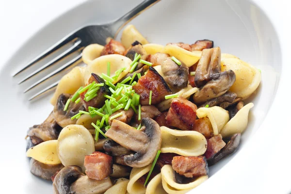 Pasta orecchiette met gebakken champignons en spek — Stockfoto