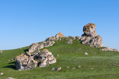 Yeşil tepe üzerinde taşlar