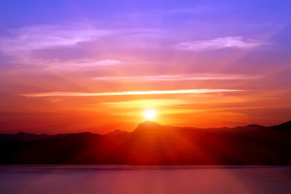 Puesta de sol sobre montañas cerca del mar — Foto de Stock