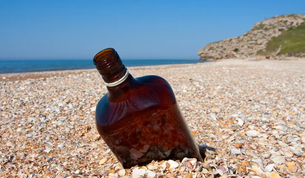 Пустая бутылка на пляже — стоковое фото